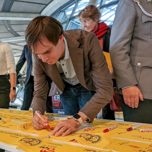 Andreas Mehltretter unterschreibt das gelbe Band der Solidarität mit Soldatinnen und Soldaten im Auslandseinsatz