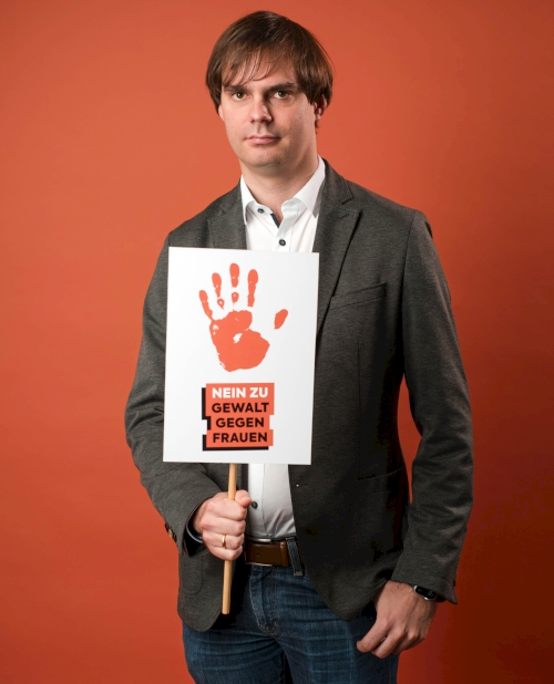 Andreas Mehltretter mit Schild "Nein zu Gewalt gegen Frauen" und roter Hand | Foto: Paul Alexander Probst